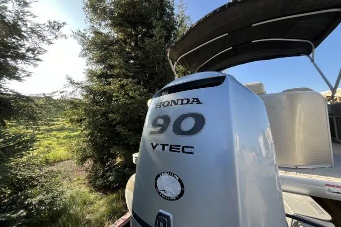 Slide: The Image of 2013 Godfry Sweetwater boat with Honda 90 VTEC engine, surrounded by trees. - 18
