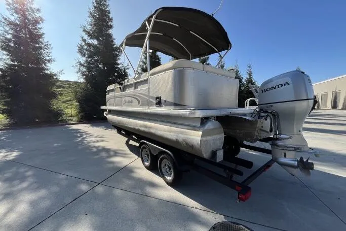 Slide: The Image of 2013 Godfry Sweetwater pontoon boat with Honda motor on trailer, parked outdoors. - 3