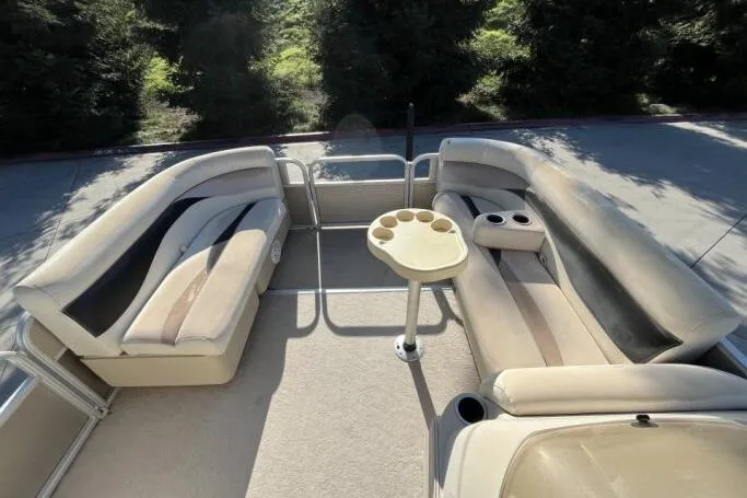 Slide: The Image of 2013 Godfry Sweetwater boat interior with beige seating and cup holders. - 9