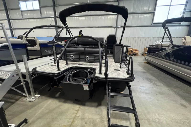 Slide: The Image of 2026 Sylvan Mirage X X3 CLZ pontoon boat in showroom, rear view with ladder. - 12