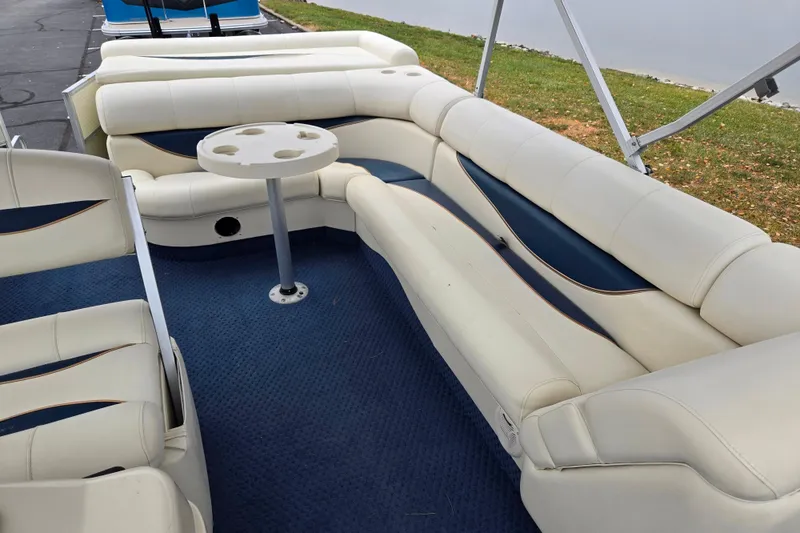 Slide: The Image of Interior of a 2005 Odyssey 522C boat with white seating and a round table. - 13