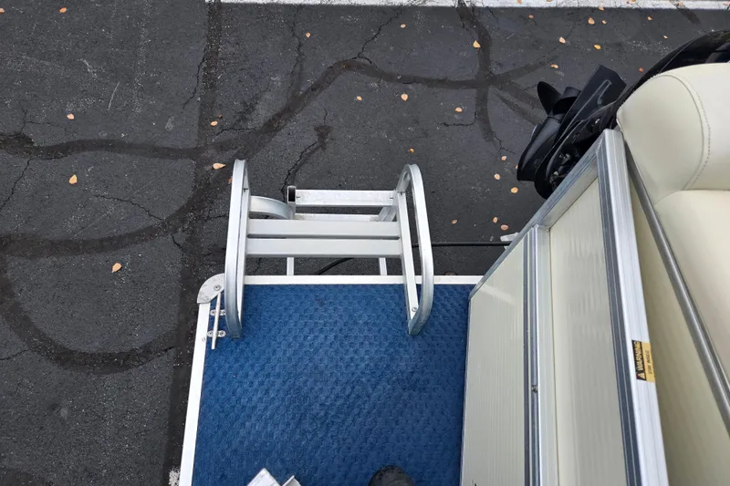 Slide: The Image of Pontoon boat deck with blue carpet and metal ladder, Odyssey 522C, 2005 model. - 16