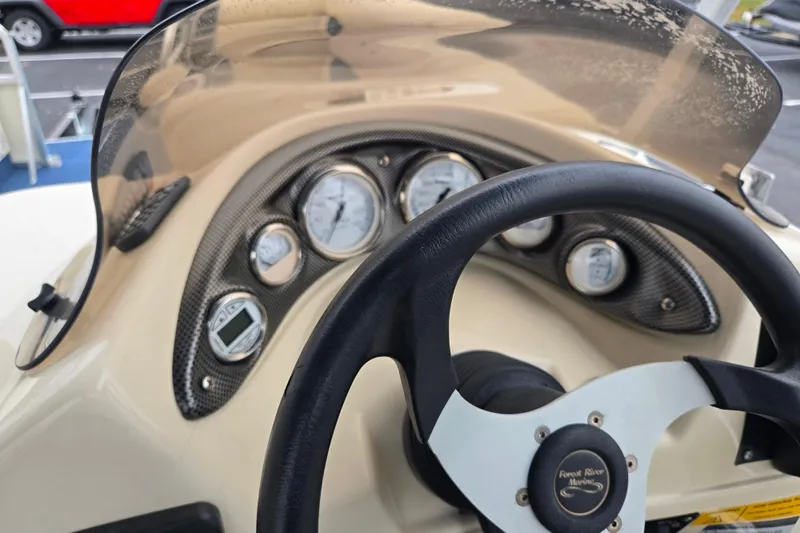 Slide: The Image of Steering wheel and dashboard of a 2005 Odyssey 522C boat with gauges and controls. - 6