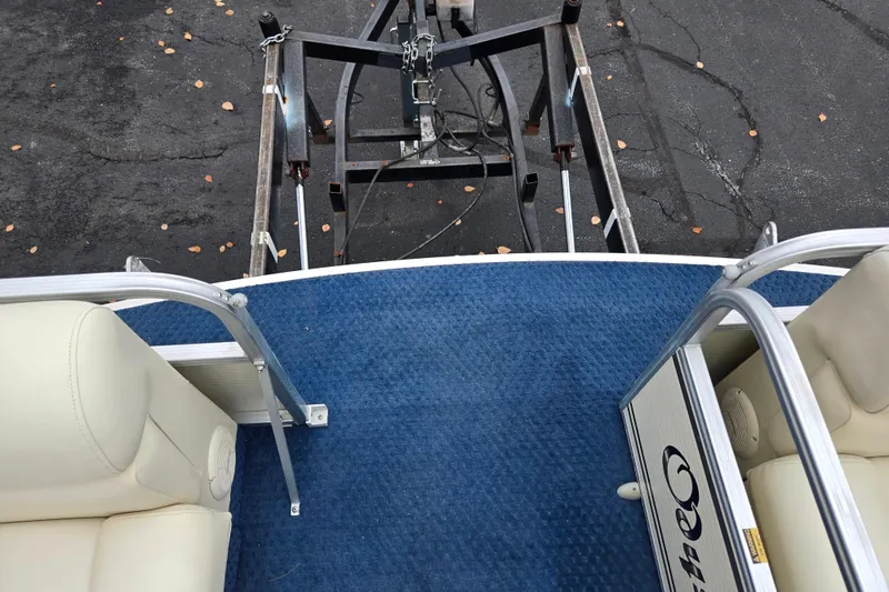 Slide: The Image of 2005 Odyssey 522C boat interior with blue carpet and cream seats, viewed from above. - 9