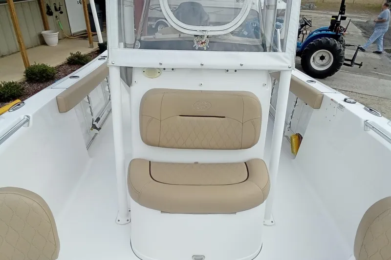 Slide: The Image of 2018 Sportsman Open 232 Center Console boat interior with tan seating and white deck. - 17