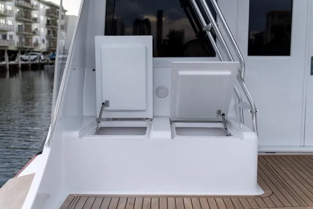 Slide: The Image of 1997 Garlington Convertible boat deck with open storage compartments, docked by waterfront buildings. - 26