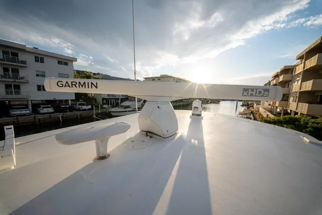 Slide: The Image of 1997 Garlington Convertible boat with Garmin xHD2 radar, docked near waterfront buildings at sunset. - 32
