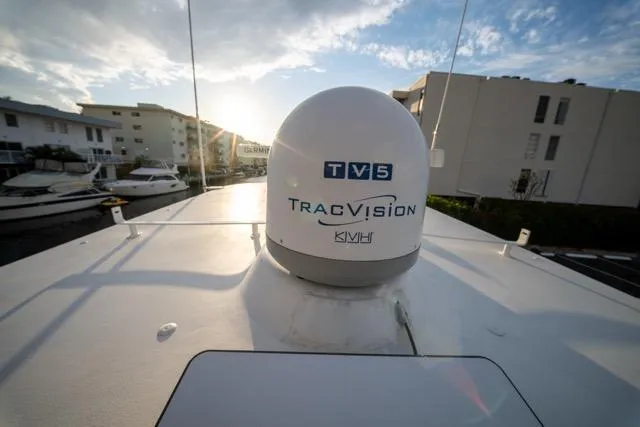 Slide: The Image of 1997 Garlington Convertible boat with TracVision TV5 satellite dome under a clear sky. - 33