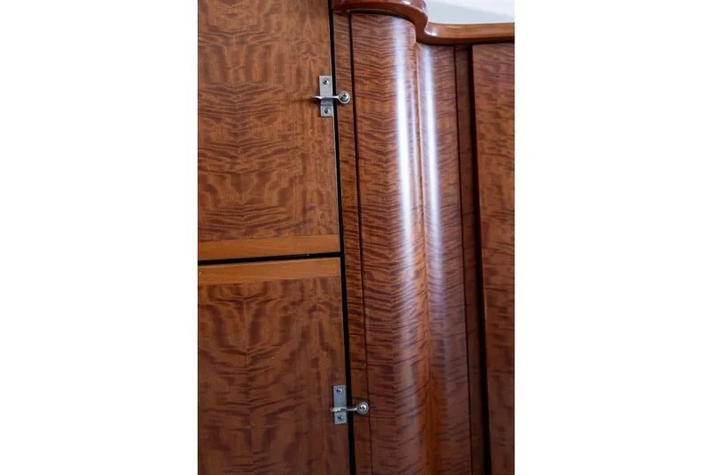 Slide: The Image of Wooden interior paneling of a 1997 Garlington Convertible, featuring elegant grain and metal hinges. - 49