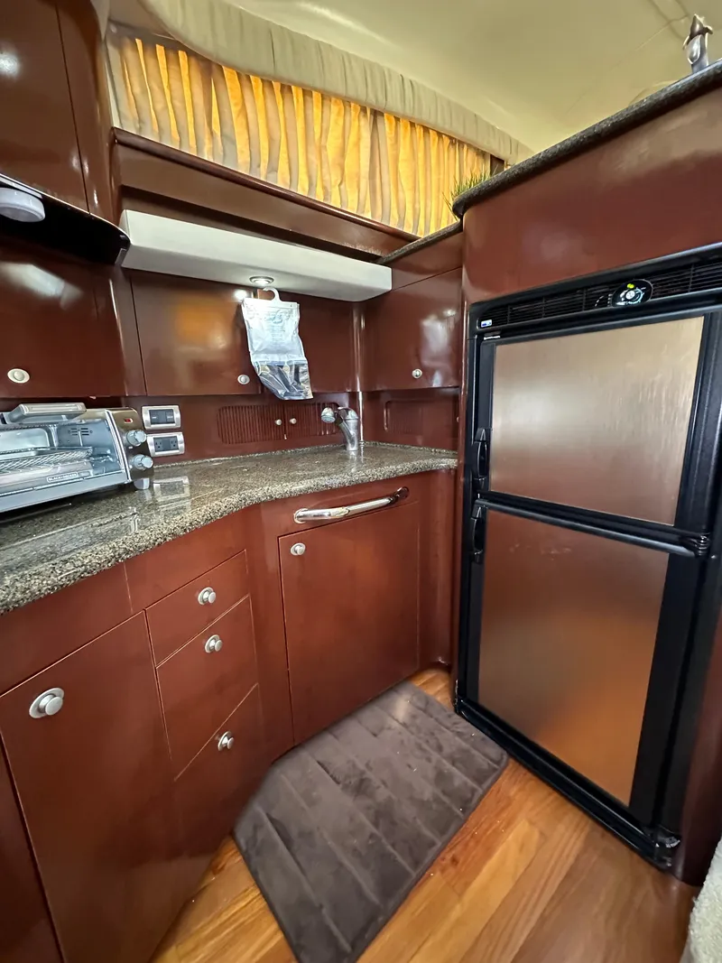 Slide: The Image of Open wooden cabinet inside 2007 Sea Ray 40 Motor Yacht, featuring shelves and a hanging rod. - 38