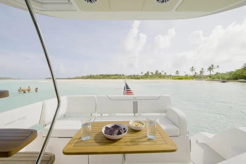 Slide: The Image of Manufacturer Provided Image: 2025 Regal 38 FXO yacht with snacks on deck, overlooking serene tropical waters. - 106