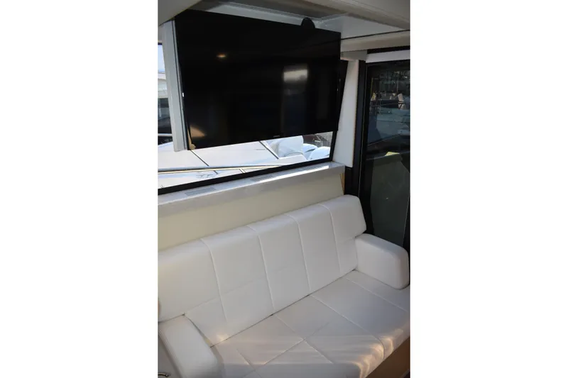 Slide: The Image of Interior of 2025 Regal 38 FXO yacht with white seating and mounted TV. - 28