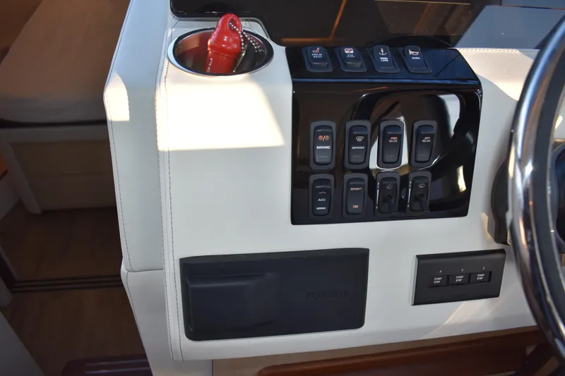 Slide: The Image of Control panel of 2025 Regal 38 FXO boat with switches and cup holder. - 35