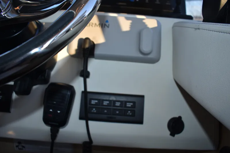 Slide: The Image of 2025 Regal 38 FXO boat dashboard with steering wheel and control panel. - 36