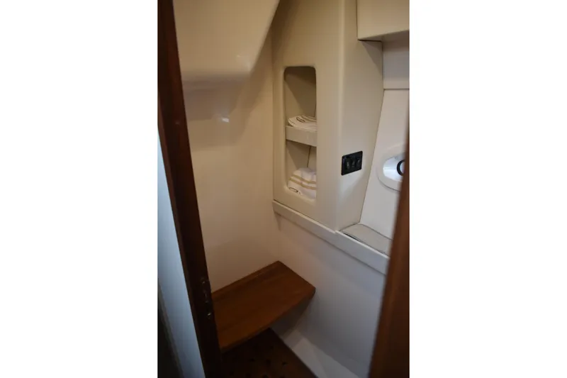 Slide: The Image of Interior of 2025 Regal 38 FXO boat, featuring compact storage and seating area. - 41