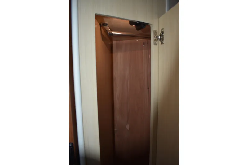 Slide: The Image of Interior closet of 2025 Regal 38 FXO yacht, featuring wooden finish and open door. - 62