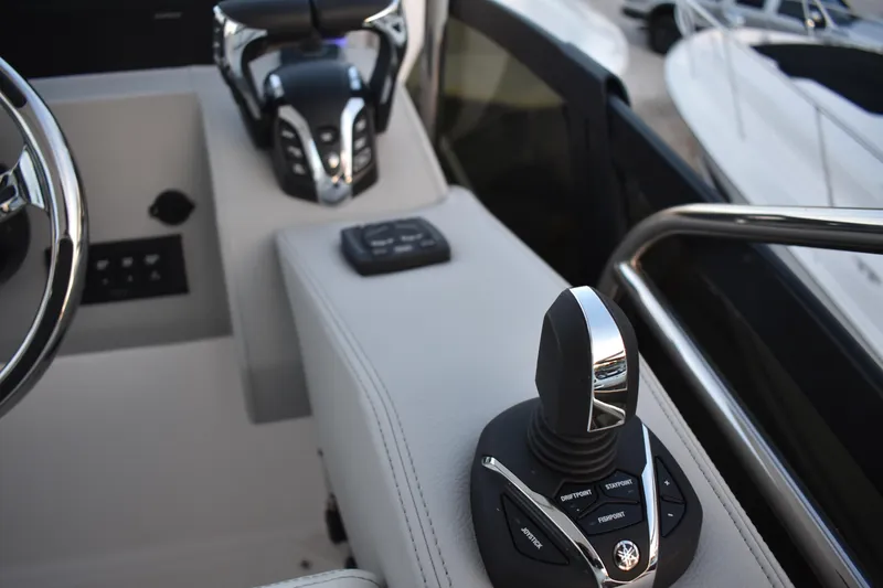 Slide: The Image of 2025 Regal 38 FXO boat cockpit with advanced joystick controls and steering wheel. - 92