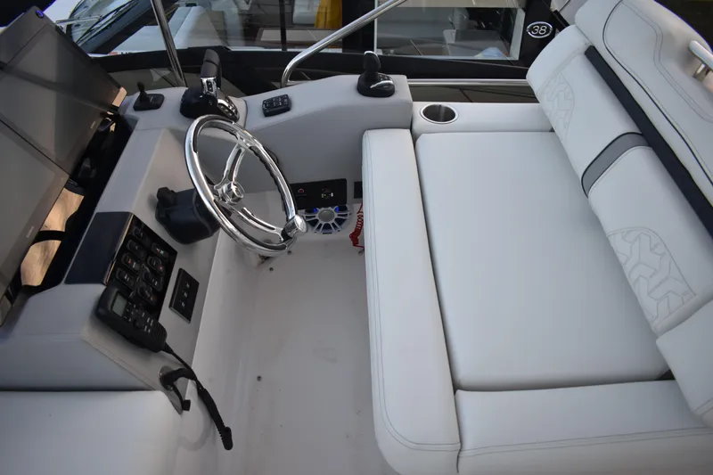 Slide: The Image of 2025 Regal 38 FXO boat interior with steering wheel and white seating. - 94