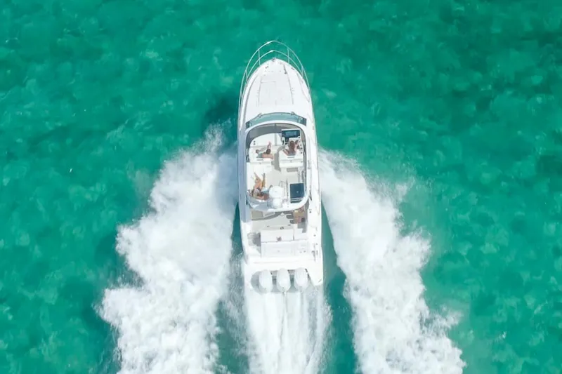 Slide: The Image of Manufacturer Provided Image: Aerial view of 2025 Regal 38 FXO boat cruising on turquoise water. - 97
