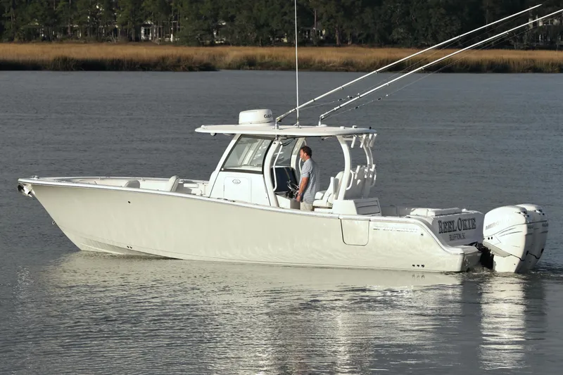 Slide: The Image of 2022 Sportsman Open 322 Center Console boat on calm water, side view. - 11