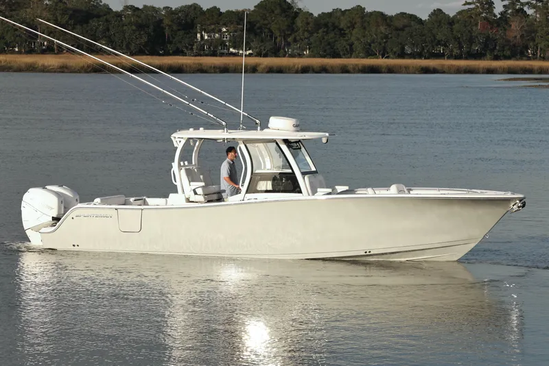 Slide: The Image of 2022 Sportsman Open 322 Center Console boat cruising on calm water. - 13
