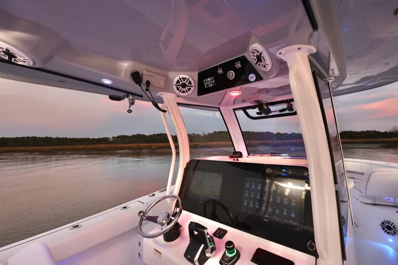 Slide: The Image of 2022 Sportsman Open 322 Center Console boat interior with advanced navigation system at sunset. - 20