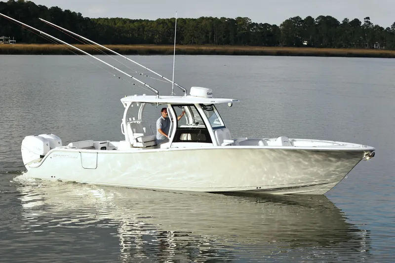 Slide: The Image of 2022 Sportsman Open 322 Center Console boat cruising on calm water. - 7