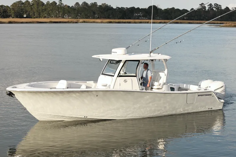 Slide: The Image of 2022 Sportsman Open 322 Center Console boat on calm water, featuring fishing rods. - 8