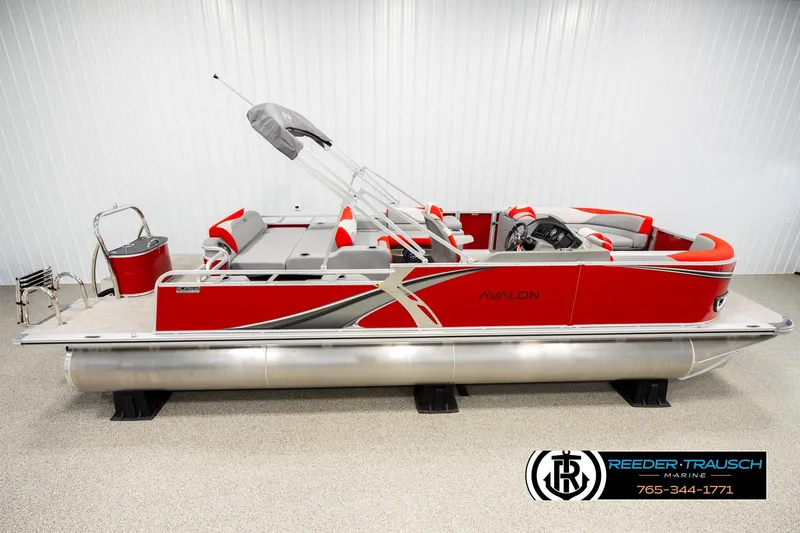The Image of 2026 Avalon LSZ Vrl pontoon boat in a showroom, featuring red and gray design. - 1