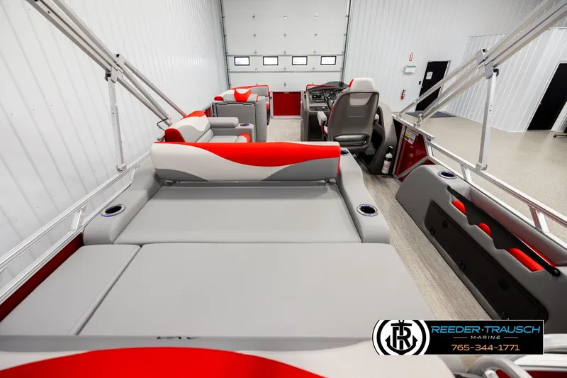 Slide: The Image of 2026 Avalon LSZ Vrl pontoon boat interior with red and gray seating in a showroom. - 16