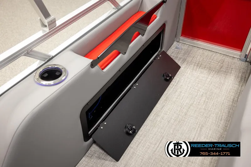 Slide: The Image of 2026 Avalon LSZ Vrl boat interior with cup holder and storage compartment, Reeder-Trausch Marine logo. - 26