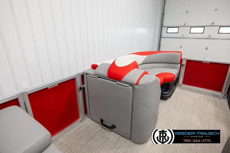 Slide: The Image of 2026 Avalon LSZ Vrl pontoon boat interior with red and gray seating in a showroom. - 27
