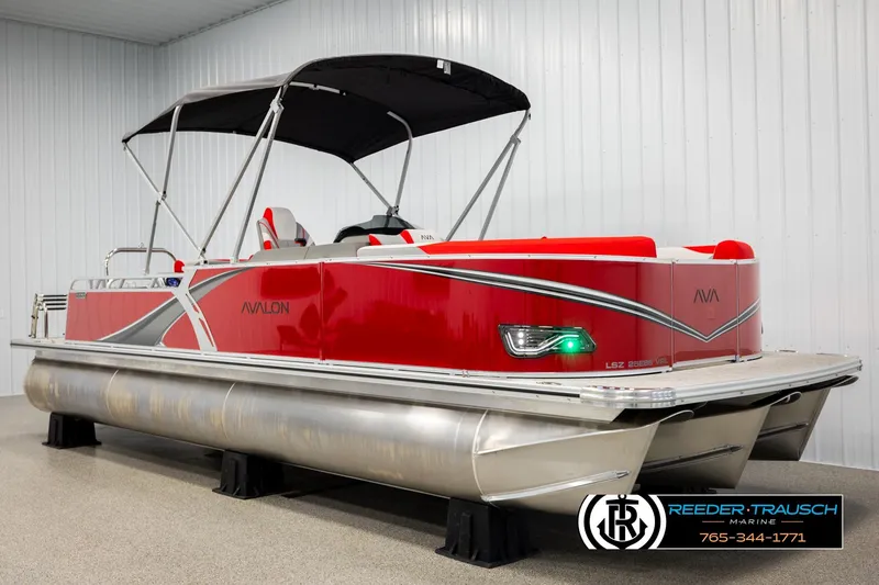 Slide: The Image of 2026 Avalon LSZ Vrl pontoon boat with red and silver design in showroom. - 3