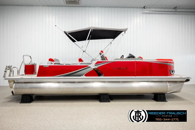 Slide: The Image of 2026 Avalon LSZ Vrl pontoon boat in showroom, featuring sleek red design and canopy. - 5