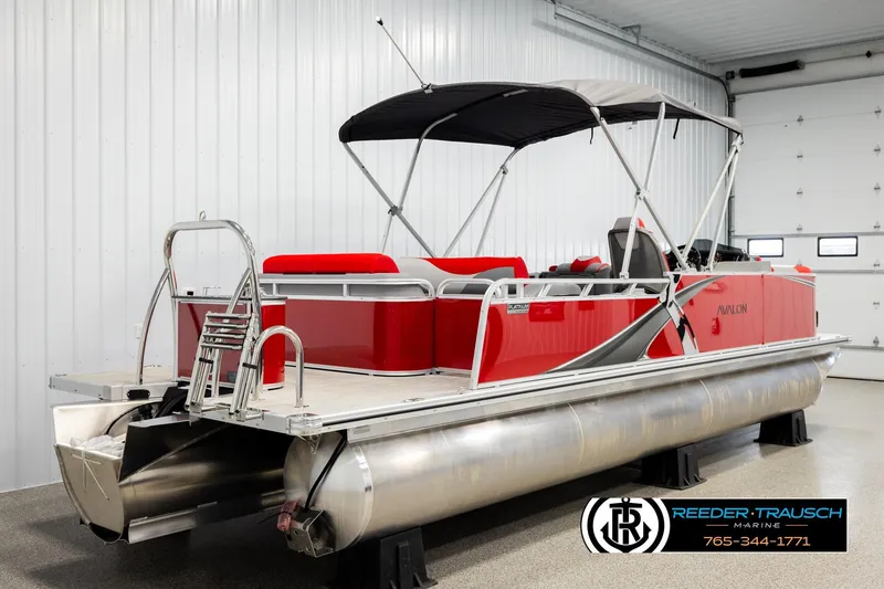 Slide: The Image of 2026 Avalon LSZ Vrl pontoon boat in a showroom, featuring red and silver design. - 6
