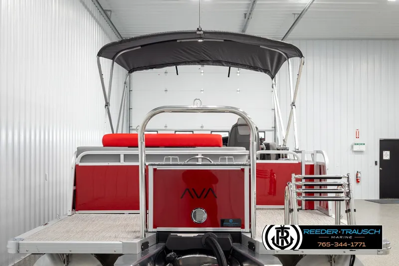 Slide: The Image of Red 2026 Avalon LSZ Vrl pontoon boat in a showroom with canopy and ladder. - 7