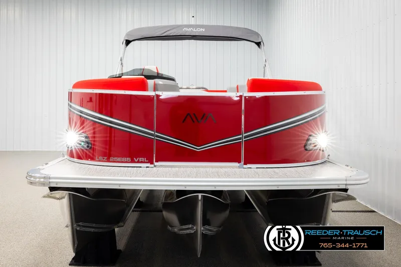 Slide: The Image of 2026 Avalon LSZ Vrl pontoon boat, red exterior, displayed indoors with lights on. - 8