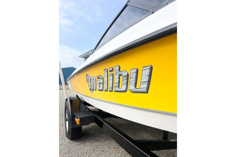 Slide: The Image of 2002 Malibu Sportster LX boat with yellow hull and trailer. - 2