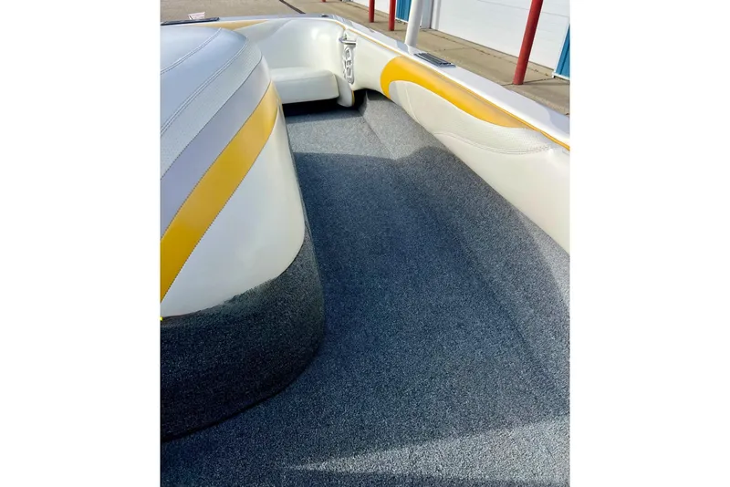 Slide: The Image of 2002 Malibu Sportster LX boat interior with gray carpet and white-yellow seating. - 30
