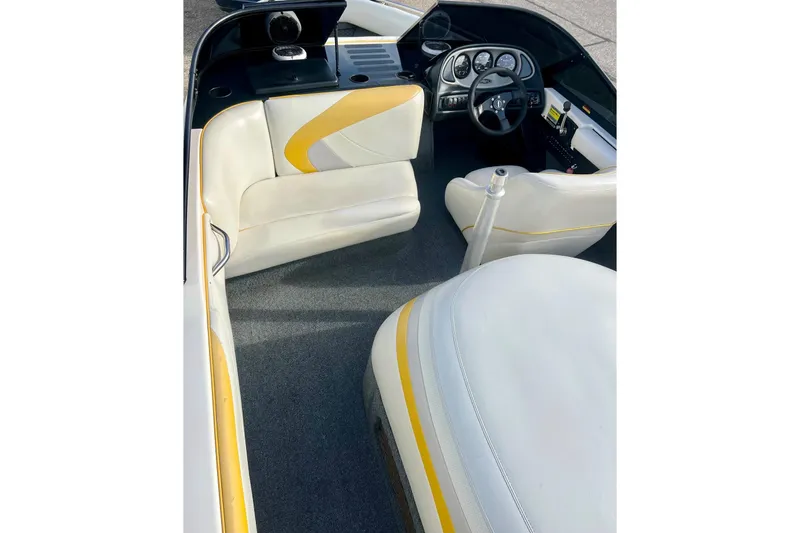Slide: The Image of 2002 Malibu Sportster LX boat interior with white and yellow seating, steering wheel, and dashboard. - 32