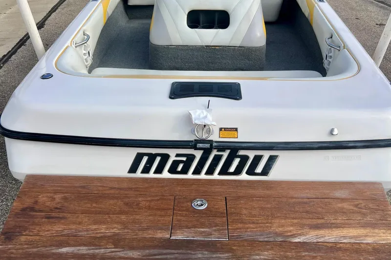 Slide: The Image of 2002 Malibu Sportster LX boat, rear view with logo and wooden deck. - 6