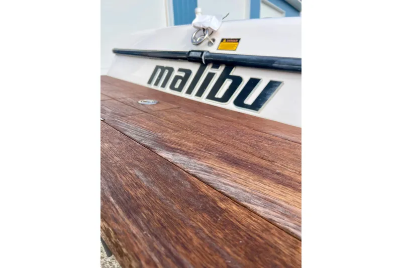 Slide: The Image of 2002 Malibu Sportster LX boat with wooden deck and logo detail. - 7