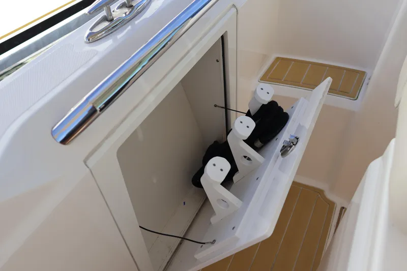 Slide: The Image of 2023 Tiara Yachts 43 LS storage compartment with organized rope holders. - 32