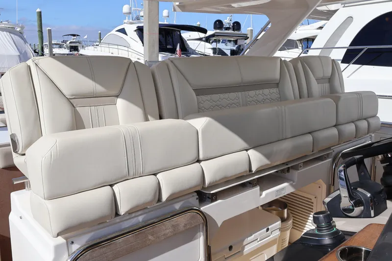Slide: The Image of 2023 Tiara Yachts 43 LS luxury seating with elegant beige upholstery at a marina. - 36
