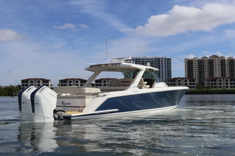 Slide: The Image of 2023 Tiara Yachts 43 LS cruising on water with cityscape backdrop. - 5