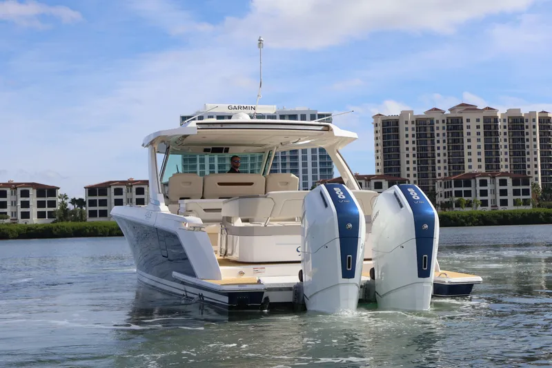 Slide: The Image of 2023 Tiara Yachts 43 LS with dual engines on water, cityscape background. - 6