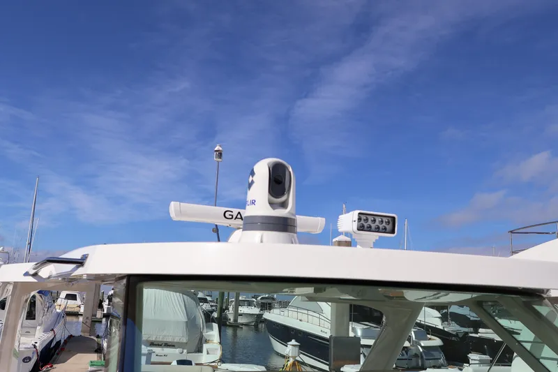 Slide: The Image of 2023 Tiara Yachts 43 LS with advanced navigation equipment under clear blue sky. - 64