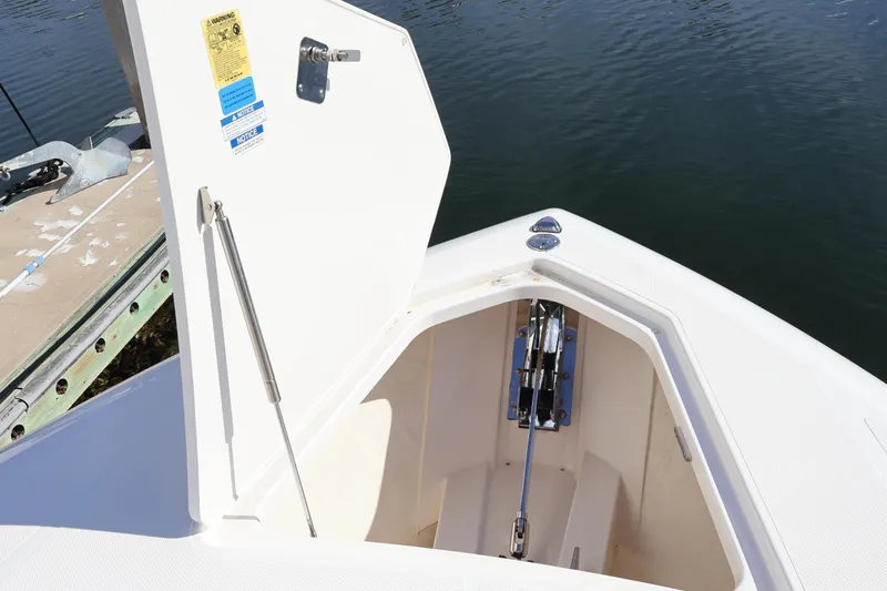 Slide: The Image of Open anchor locker on 2023 Tiara Yachts 43 LS, showing anchor mechanism by the water. - 67
