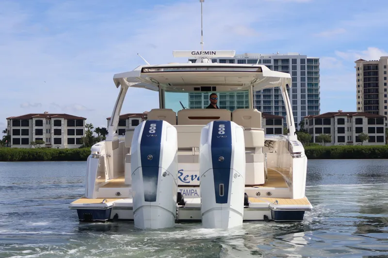 Slide: The Image of 2023 Tiara Yachts 43 LS cruising on water with cityscape backdrop. - 7