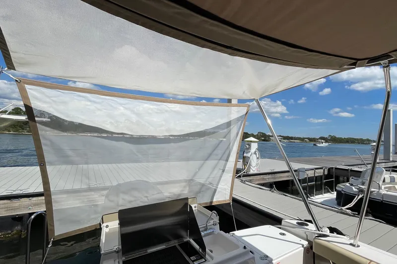 Slide: The Image of 2025 Ranger Tugs R-27 Seakeeper Ride at dock with sunshade and scenic water view. - 14